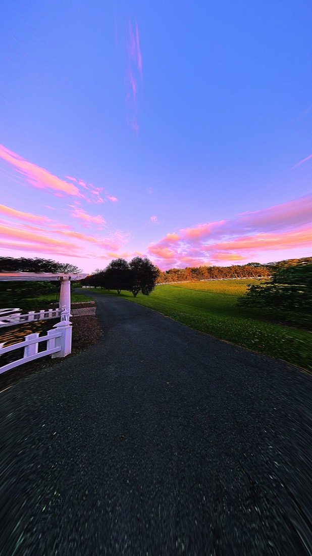 Photo shot with Liquid Lens: white fence path under a pink sunset sky